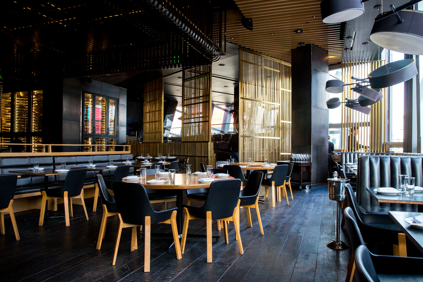 The Alcaraván dining room by day, with pendant lamps and an open bar