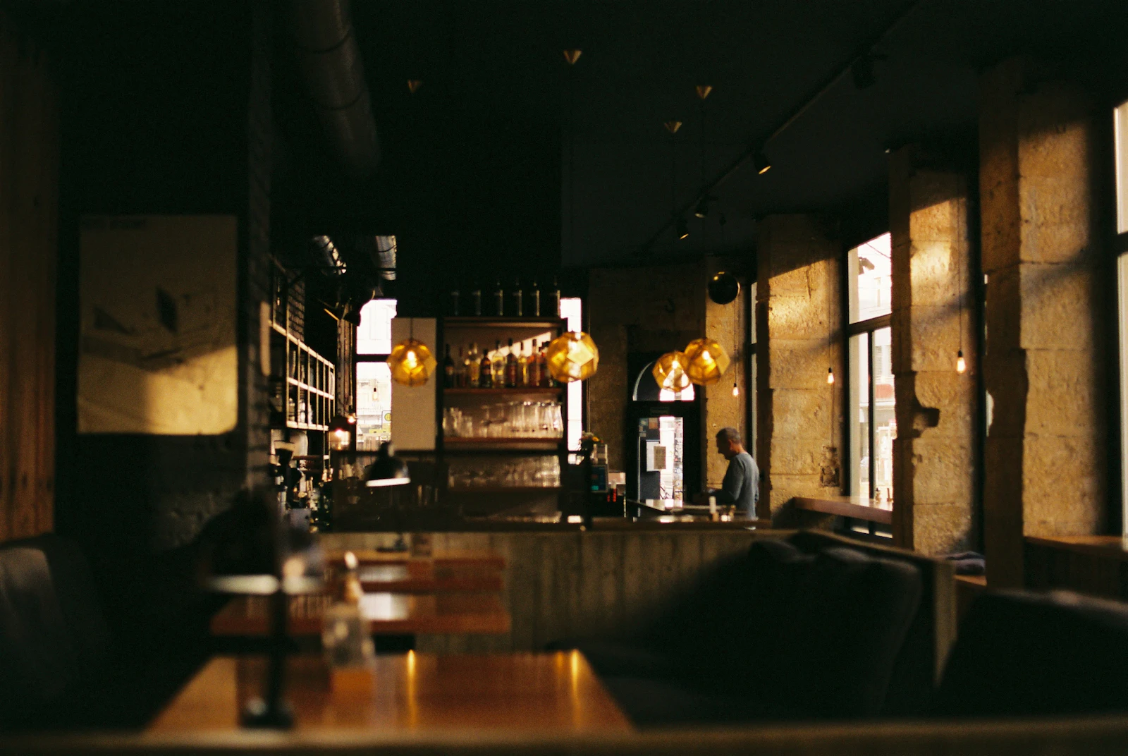 The Alcaraván dining room at night, warm pendant lights over wooden tables